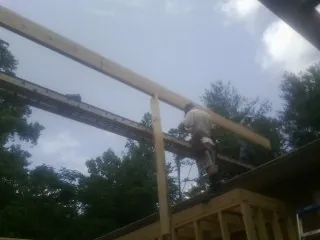 Carpenter setting a ridge beam over a new addition frame — Ice Dam Removal by Roofing Brothers in Pierrepont Manor