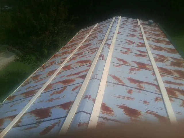 Rusted metal roof panels with new wood purlins before replacement — Storm Damage Roof Repair in Pierrepont Manor by Roofing Brothers