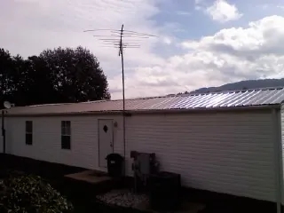 New metal roof on a single wide mobile home with a TV antenna in Pierrepont Manor