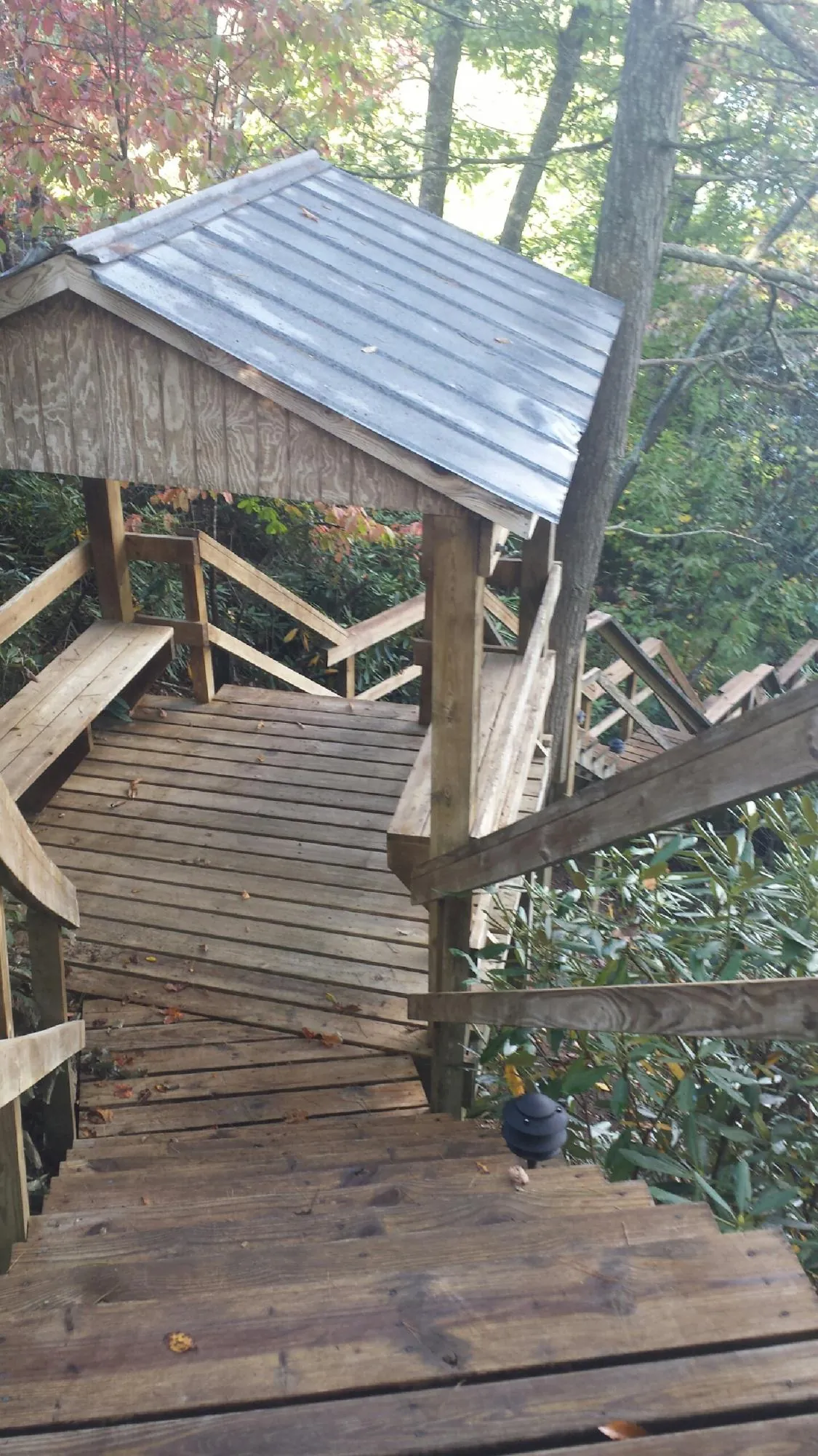 Metal roofed shelter over wooden steps on a wooded walkway — Skylight Repair & Installation work by our crew in Pierrepont Manor