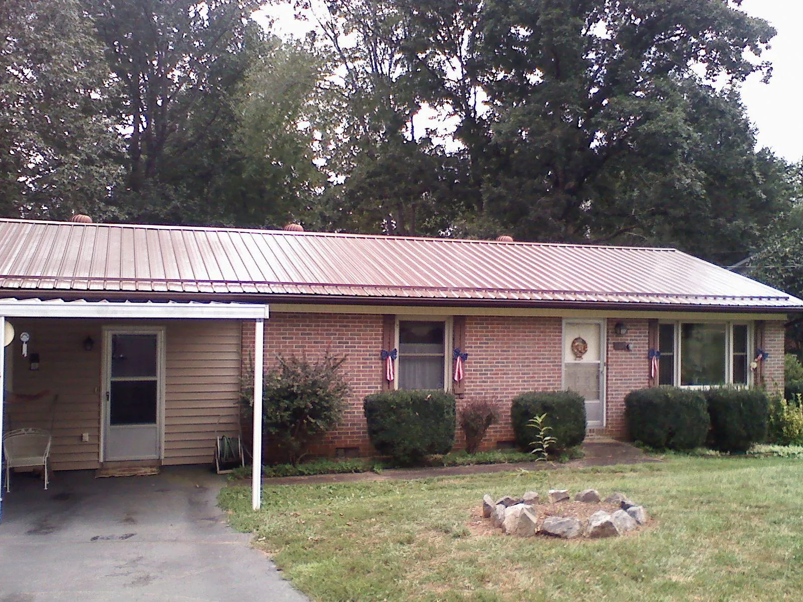 Bronze metal roof and carport on a brick ranch home — Roof Repair work by our crew in Pierrepont Manor